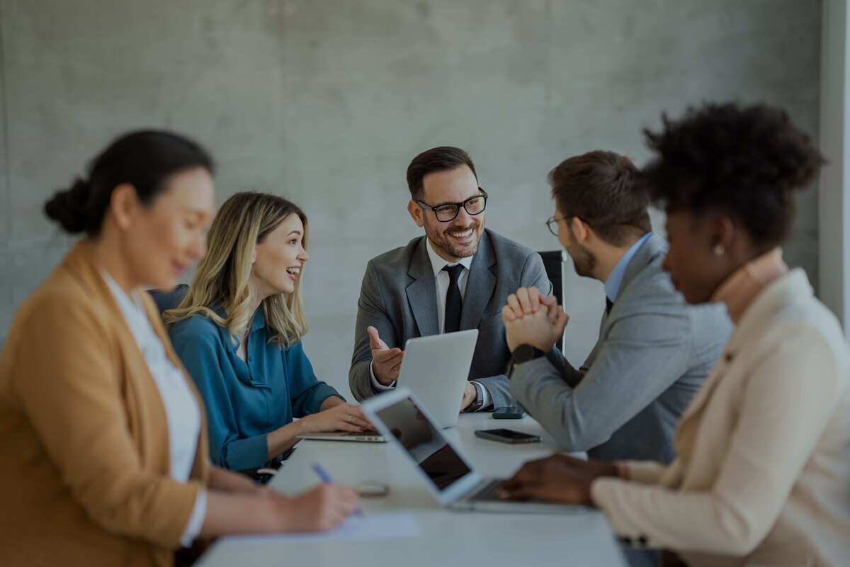 Several people sitting around a table in a meeting Several people sitting around a table in a meeting